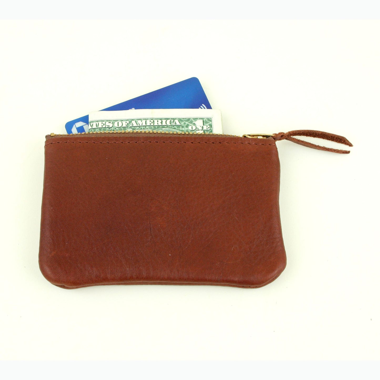 Brown leather coin purse with a credit card and folded in half dollar bill tucked into it to show size.