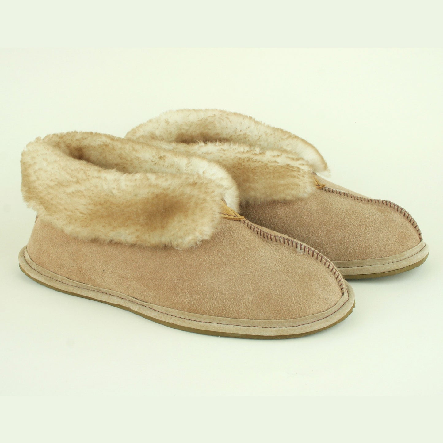 Side view of women's sheepskin slippers with traction soles.