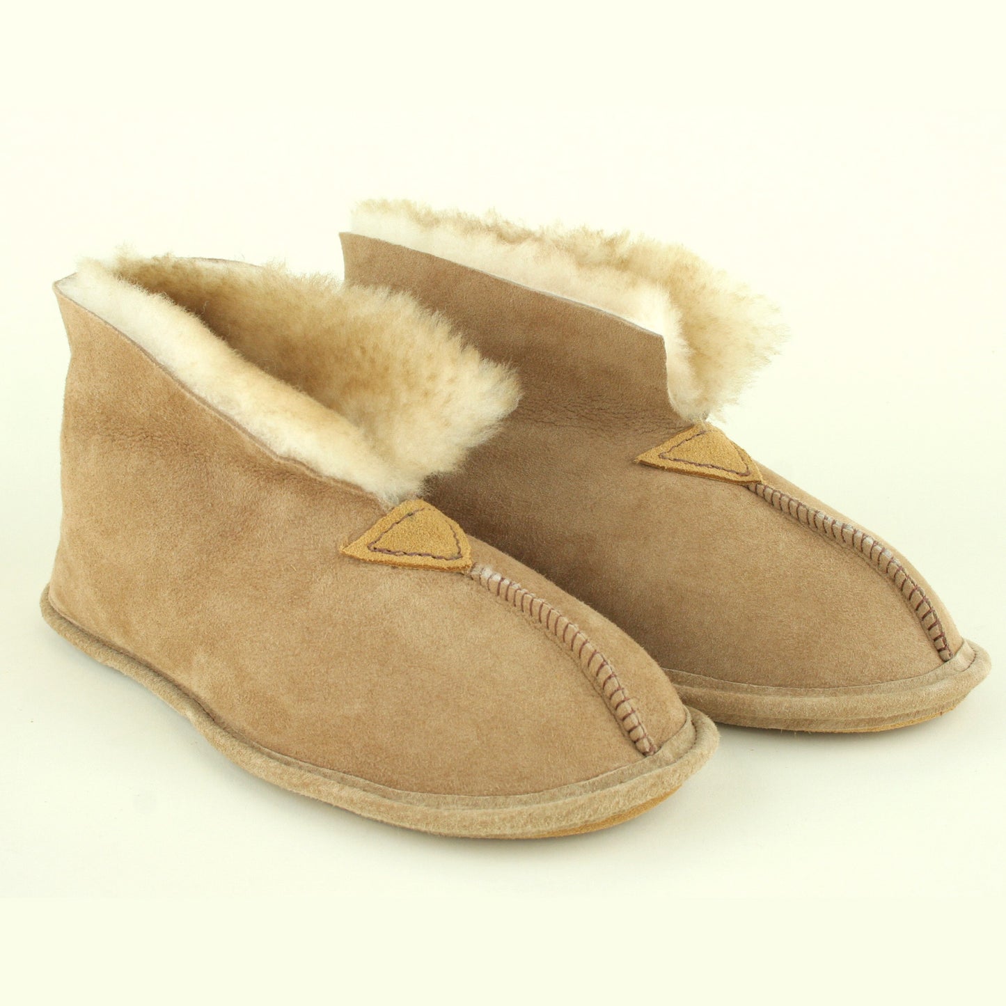 Women's sheepskin slippers with cuffs flipped up.