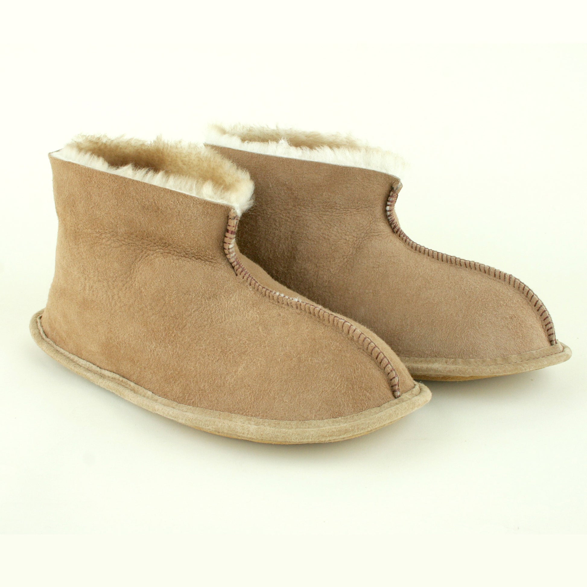 Men's sheepskin slippers with cuff flipped up.